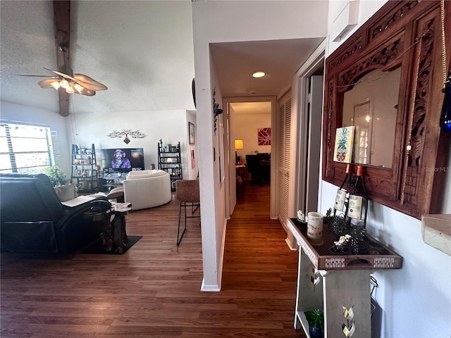 hallway featuring vaulted ceiling, a textured ceiling, and wood finished floors