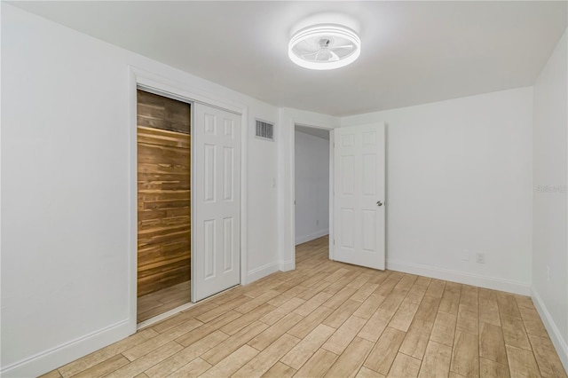 unfurnished bedroom with a closet and light hardwood / wood-style flooring