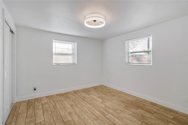 unfurnished room with a healthy amount of sunlight and light hardwood / wood-style floors