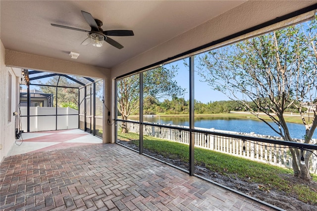 unfurnished sunroom with a water view and ceiling fan