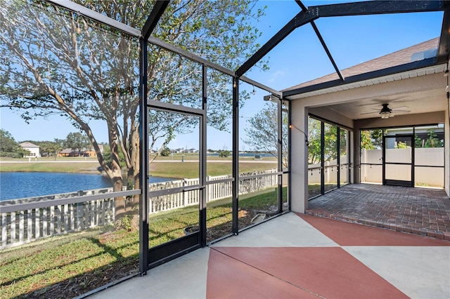 unfurnished sunroom featuring a water view and ceiling fan