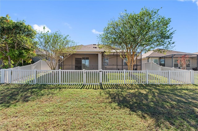 view of front of property featuring a front yard and a sunroom