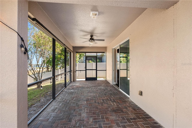 unfurnished sunroom with ceiling fan