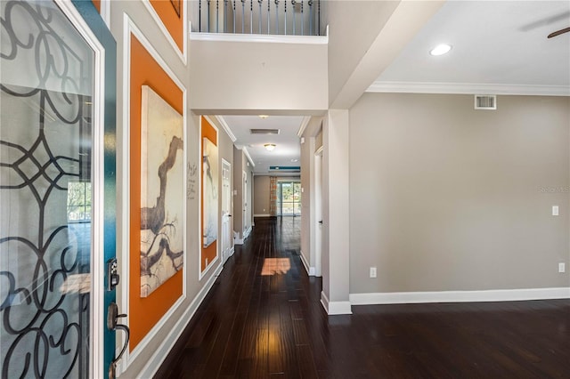 foyer entrance with crown molding and dark hardwood / wood-style floors