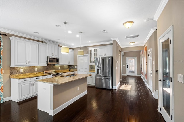 kitchen with a center island with sink, white cabinets, stainless steel appliances, and hanging light fixtures