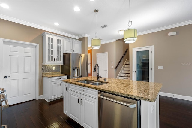 kitchen featuring appliances with stainless steel finishes, dark hardwood / wood-style flooring, sink, white cabinets, and hanging light fixtures