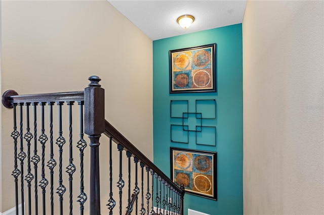 stairs featuring a textured ceiling