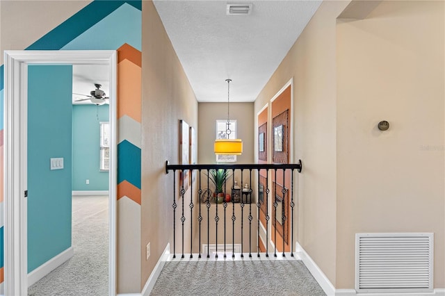 corridor featuring carpet floors and a textured ceiling