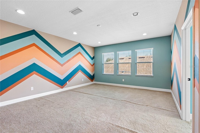 spare room with a textured ceiling and carpet floors