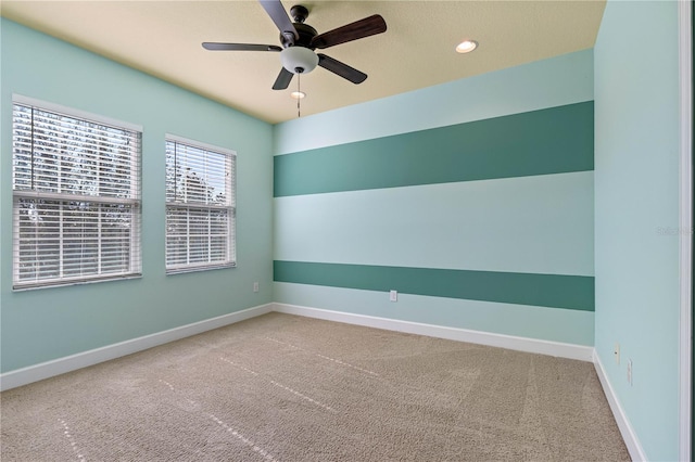 carpeted spare room featuring ceiling fan