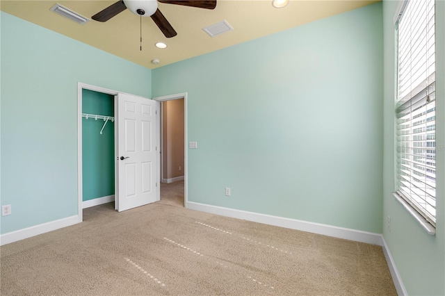 unfurnished bedroom with ceiling fan, a closet, and carpet