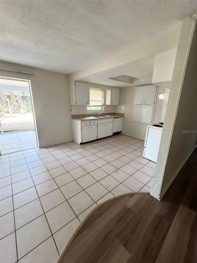 kitchen with sink, white cabinets, light tile patterned floors, and white electric range