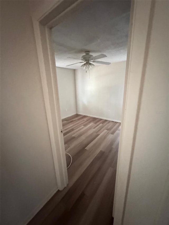 unfurnished room with wood-type flooring, a textured ceiling, and ceiling fan