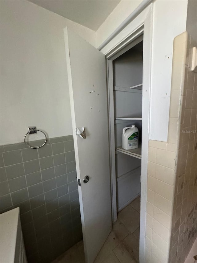 bathroom with tile patterned flooring and tile walls