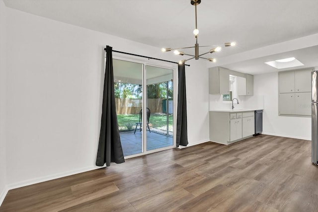 980 5th Ave NE, Largo, FL 33770 - kitchen featuring a chandelier, wood finished floors, light countertops, and dishwasher