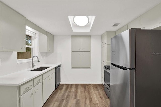 980 5th Ave NE, Largo, FL 33770 - kitchen with stainless steel appliances, wood finished floors, and light countertops