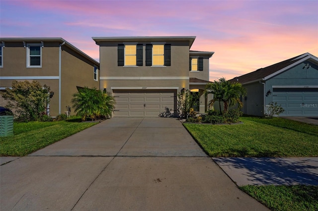 front facade with a garage and a yard