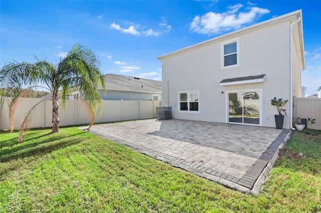 rear view of house with a yard and a patio