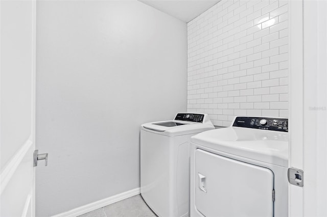 clothes washing area with light tile patterned floors and washing machine and dryer