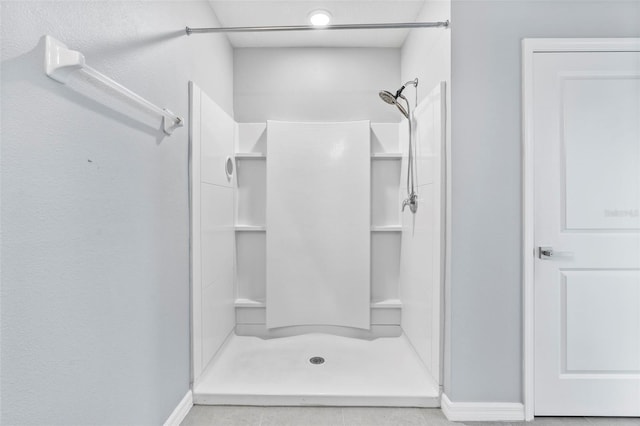 bathroom with tile patterned flooring and walk in shower