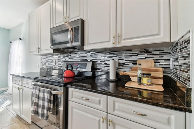 kitchen with appliances with stainless steel finishes, white cabinetry, and light tile patterned flooring