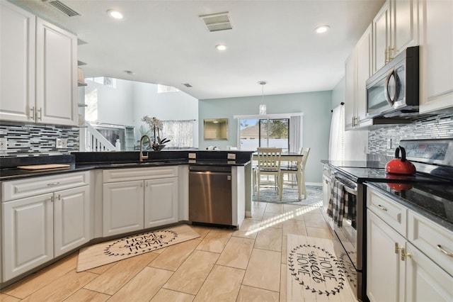 kitchen with white cabinetry, sink, hanging light fixtures, tasteful backsplash, and appliances with stainless steel finishes