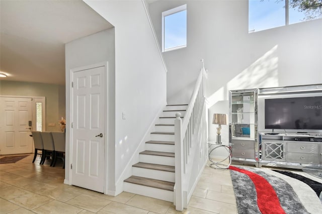 stairway featuring a wealth of natural light and tile patterned flooring