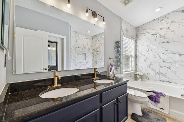 bathroom with vanity, toilet, and a bathtub