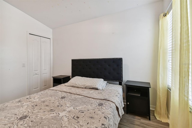 bedroom featuring a closet, wood-type flooring, and vaulted ceiling