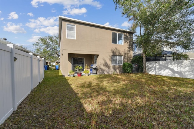 rear view of house with a lawn and central air condition unit