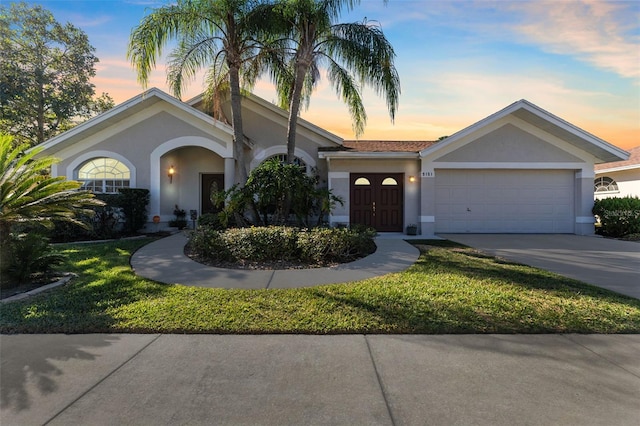 single story home with a lawn and a garage