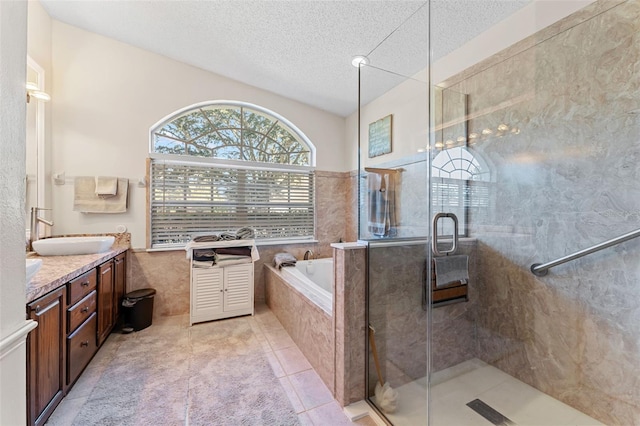 bathroom featuring tile patterned floors, a textured ceiling, vanity, independent shower and bath, and tile walls