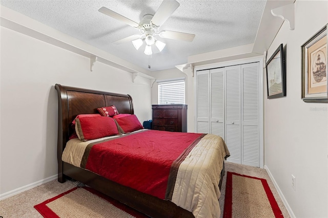 carpeted bedroom featuring ceiling fan, a closet, and a textured ceiling