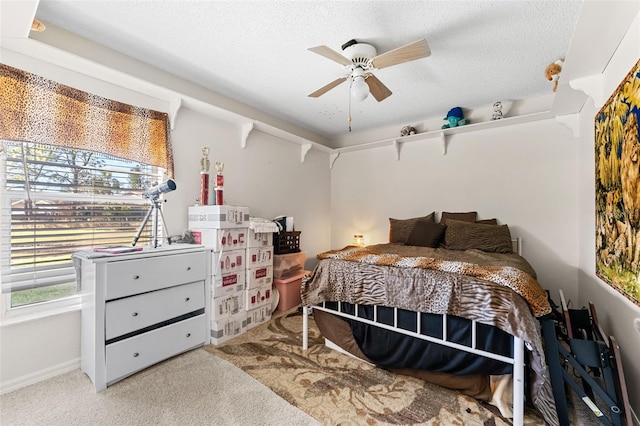 carpeted bedroom with ceiling fan and a textured ceiling