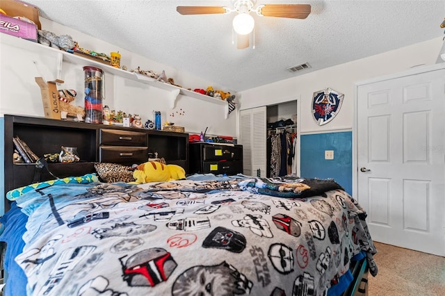 carpeted bedroom with ceiling fan, a closet, and a textured ceiling