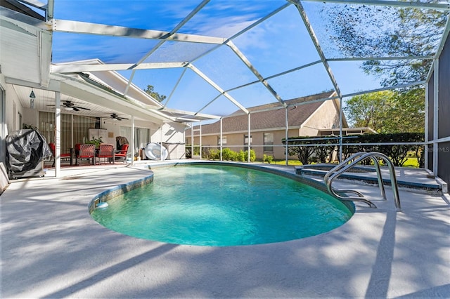 view of swimming pool with glass enclosure, ceiling fan, and a patio area