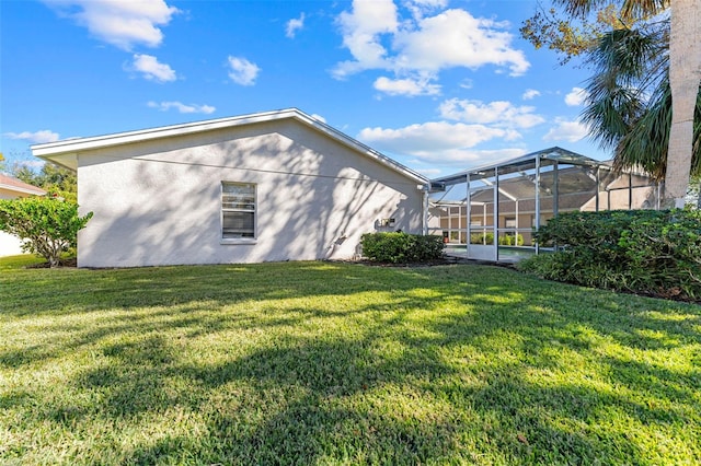 exterior space featuring a lawn and glass enclosure