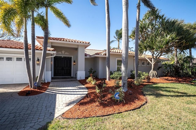 mediterranean / spanish house with a garage and a front yard