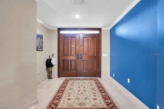 entrance foyer featuring ornamental molding and a textured ceiling