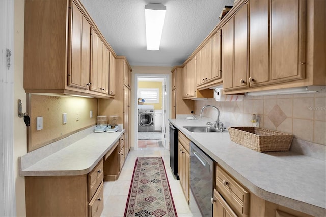 kitchen with washer and dryer, black dishwasher, sink, backsplash, and stainless steel dishwasher