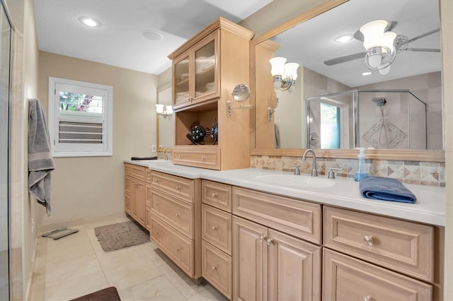 bathroom featuring a shower with door, ceiling fan, backsplash, vanity, and tile patterned floors