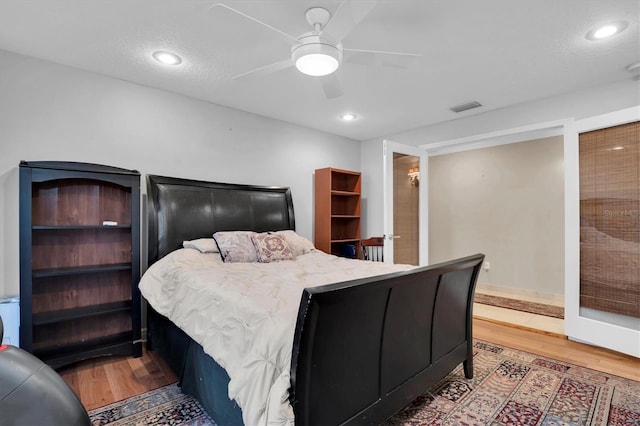 bedroom with hardwood / wood-style floors, a textured ceiling, and ceiling fan