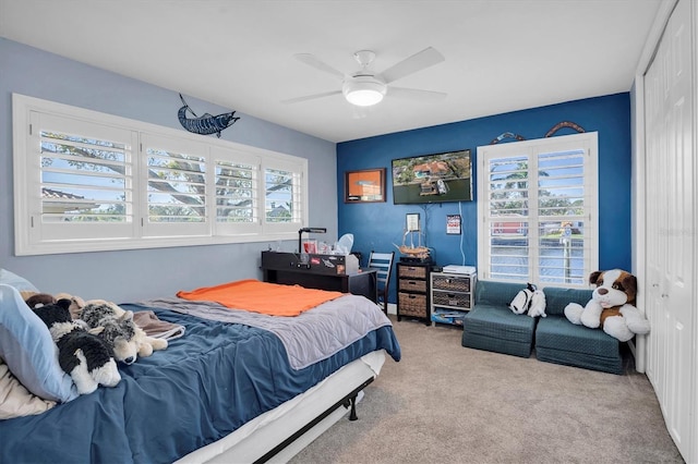 carpeted bedroom with ceiling fan and a closet