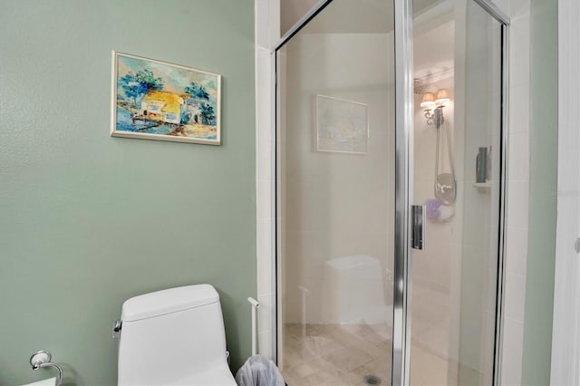 bathroom with a shower with door and toilet