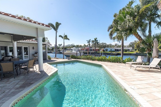 view of pool with a water view and a patio area