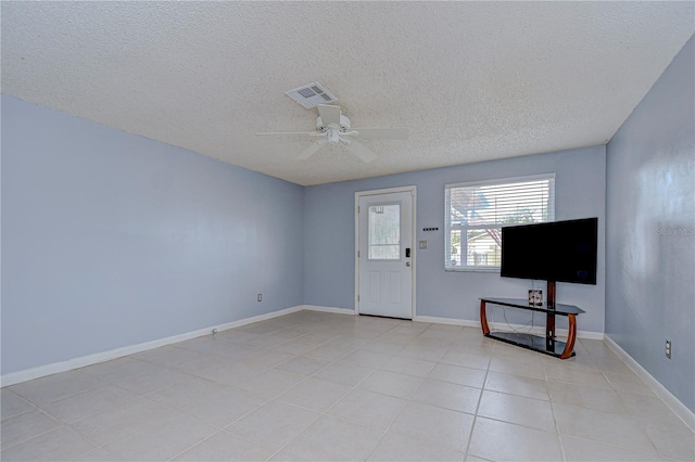 unfurnished living room with ceiling fan, light tile patterned floors, and a textured ceiling