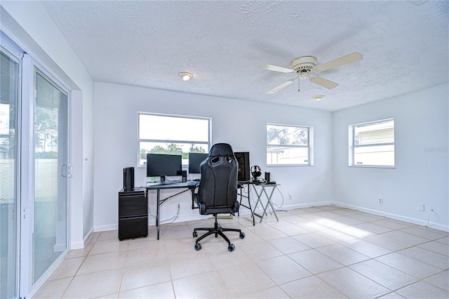 home office featuring ceiling fan, light tile patterned floors, and a textured ceiling