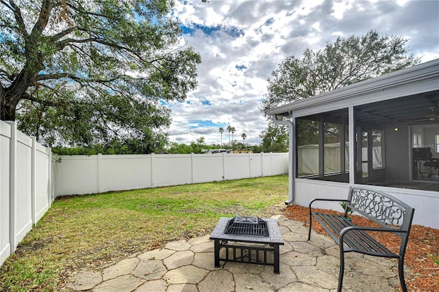 view of yard with a patio area, a sunroom, and a fire pit