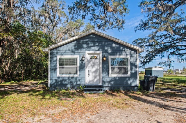 bungalow-style home with a storage shed