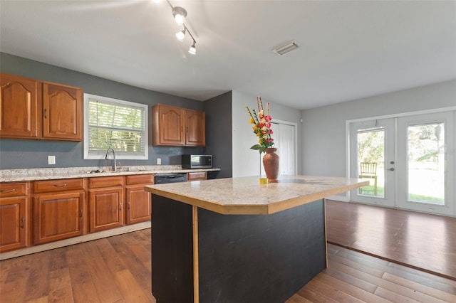 kitchen with french doors, a center island, a healthy amount of sunlight, and wood-type flooring